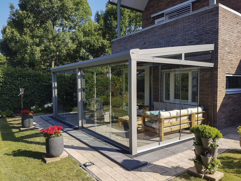 Terrassenüberdachung mit Glasschiebetüren am Klinkerhaus Terrassenüberdachung Classic L mit Glasschiebetüren an Klinkerhaus mit Lounge-Möbeln