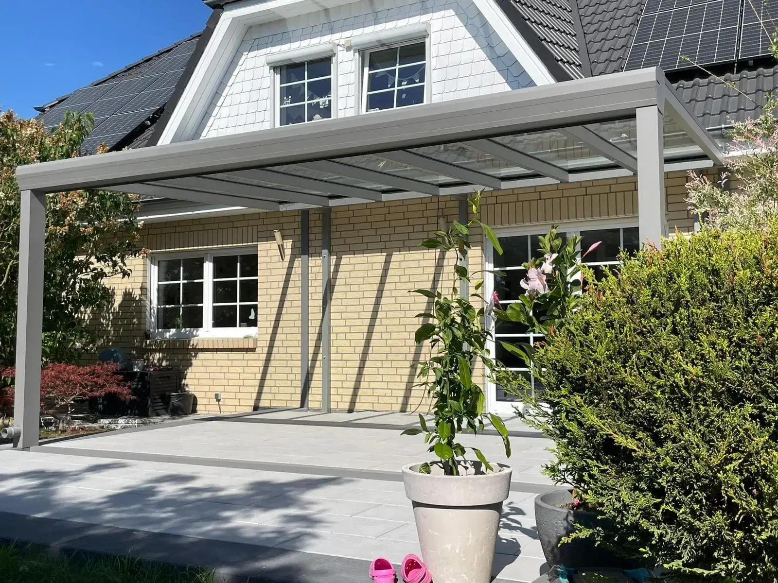 Offene Terrassenüberdachung Classic L in Grau vor einem Einfamilienhaus